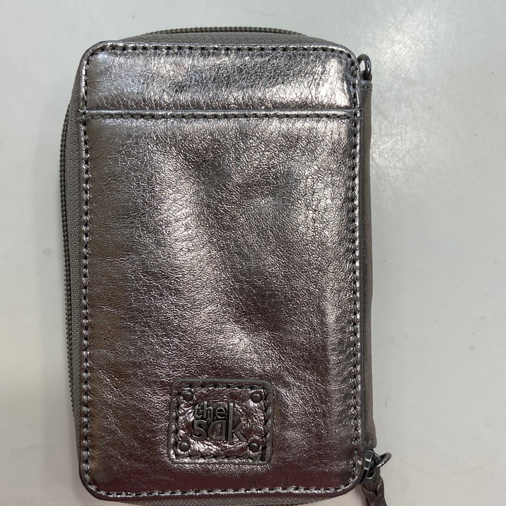 The Sak wristlet. Silver/pewter color. Like new, barely used.Perfect condition